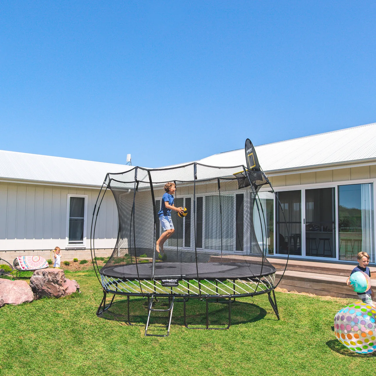 Springfree O77 Medium Oval Trampolin vor einem Haus.