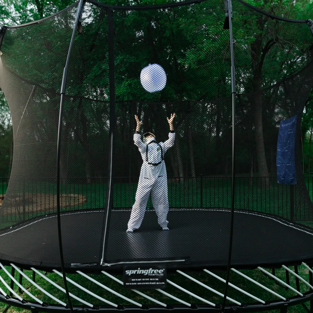 Kind mit Ball auf dem Springfree S113 Large Square Trampolin.