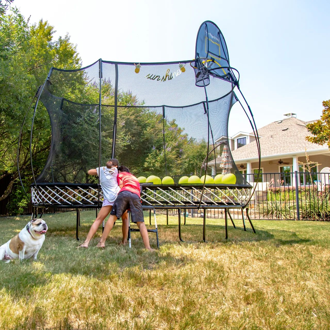 Familie beim Springfree O77 Medium Oval Trampolin im Garten.