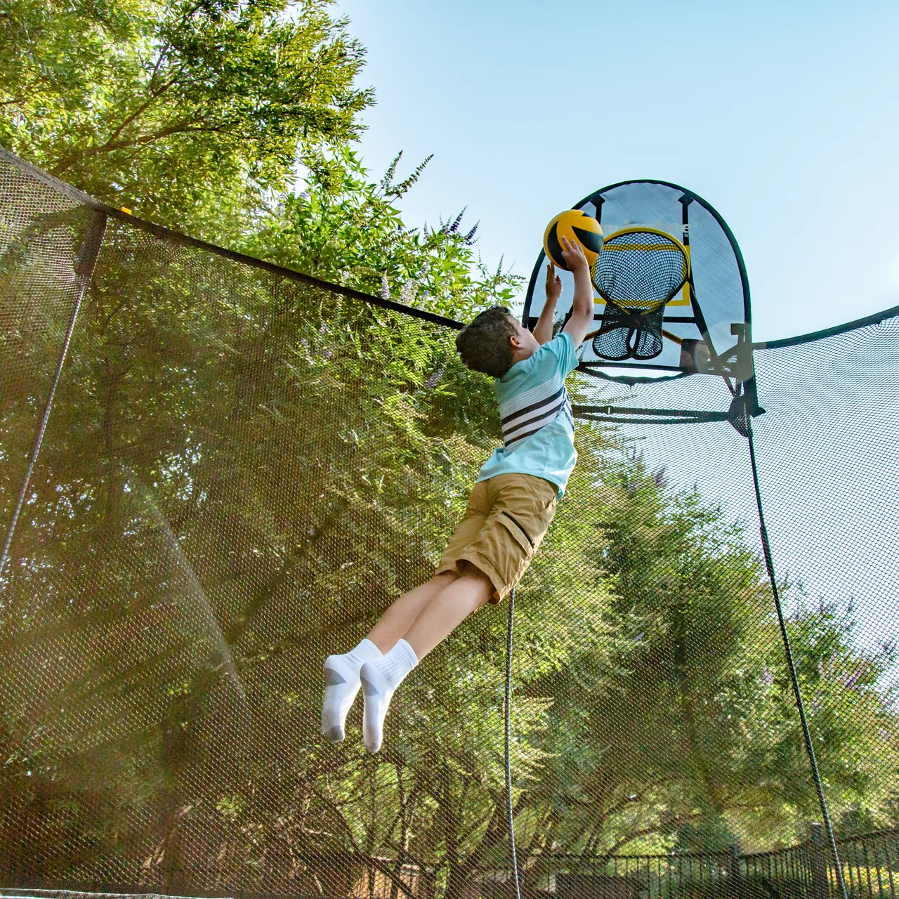 Kind unter dem Basketballkorb am Springfree O92 Large Oval Trampolin.